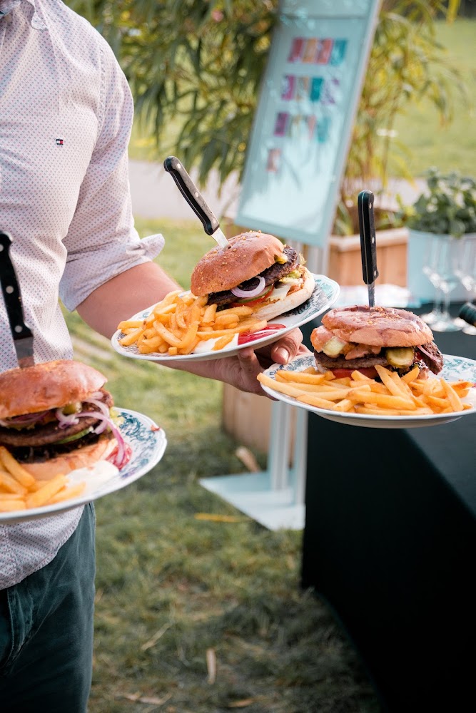 Servicekraft trägt Burger-Teller beim Outdoor-Event am Heißen Franken