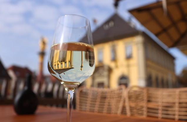 Weinglas mit Frankenwein Silvaner vor dem Panorama von Eibelstadt und der Mainschleife