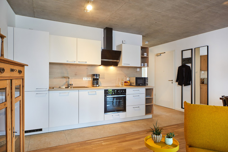 Vollausgestattete moderne Küche mit Backofen, Kaffeemaschine und Holzarbeitsplatte – Ferienwohnung Weinforum Franken