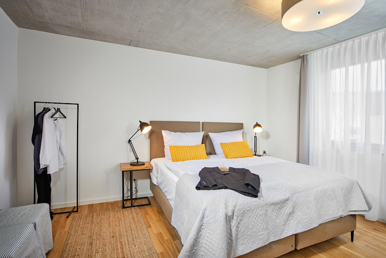 Großzügiges Schlafzimmer mit Boxspringbett und Bademantel in der Ferienwohnung Weinforum Franken Eibelstadt