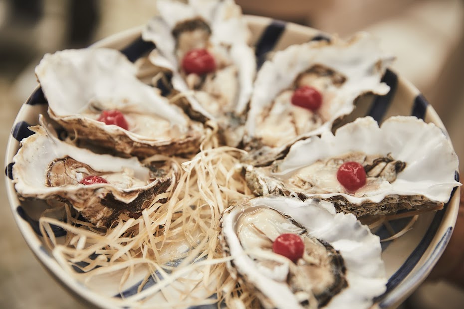 Frische Austern auf Stroh und blau-weißem Manufaktur-Geschirr – Meeresfrüchte Spezialität im Weinforum Franken